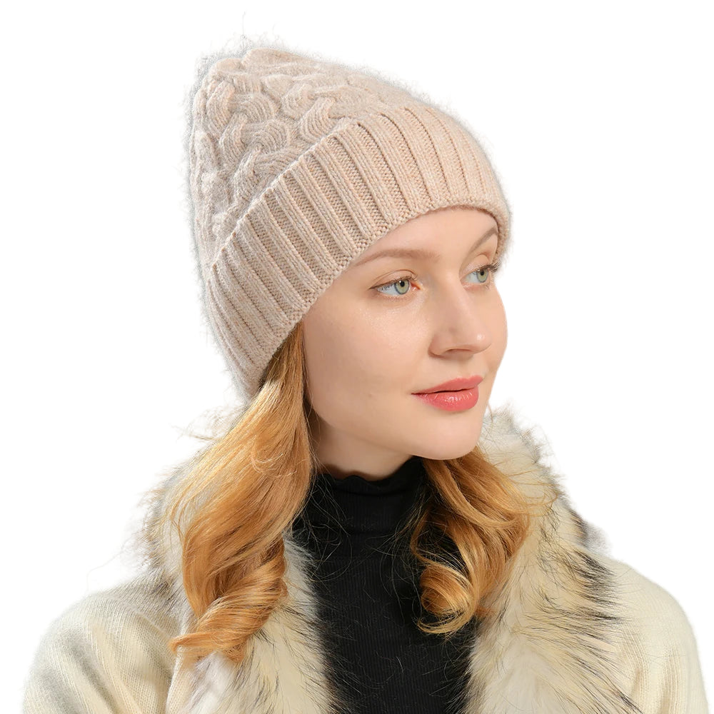 Woman wearing a beige knitted hat and fur-lined coat against a gray background