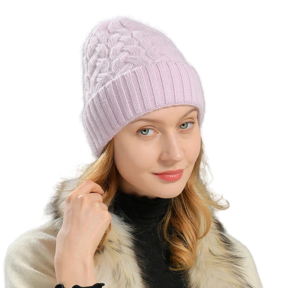 Woman wearing a pink knitted beanie against a gray background