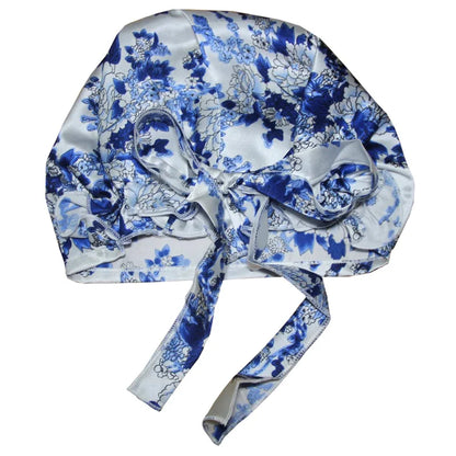 Blue floral satin bonnet with a bow, designed for hair protection during sleep, with a beautiful floral pattern on a light satin background