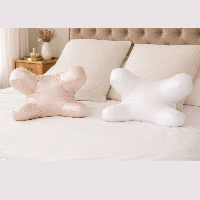 Champagne and white side sleeper pillows displayed on a neatly styled bed in a soft neutral bedroom setting