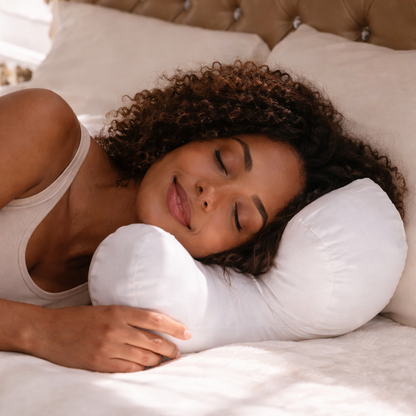 Curly-haired woman sleeping on a white side sleeper pillow for soft neck support and comfortable rest